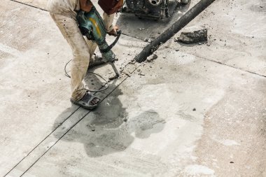 İnşaat işçisi beton sondaj yüzeyi kullanıyor.