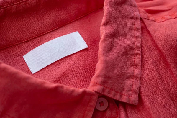 Etiqueta Blanca Etiqueta Ropa Blanco Sobre Tela Camisa Lino Rojo — Foto de Stock