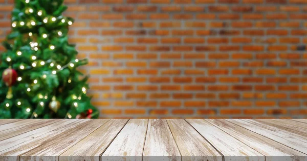 空の木のテーブルの上にぼかしで装飾されたクリスマスツリーレンガの壁の背景に赤ちゃん — ストック写真