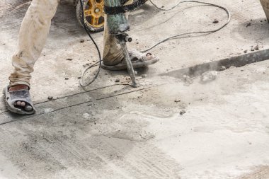 İnşaat işçisi beton sondaj yüzeyi kullanıyor.
