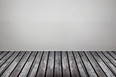 Ahşap zemin odası olan boş beyaz beton duvar.