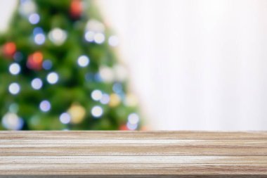 Bokeh ışıklandırmalı bulanık Noel ağacıyla boş masa üstü