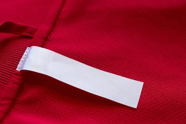 Etiqueta Ropa Blanca Blanco Sobre Fondo Textura Jersey Rojo — Foto de Stock