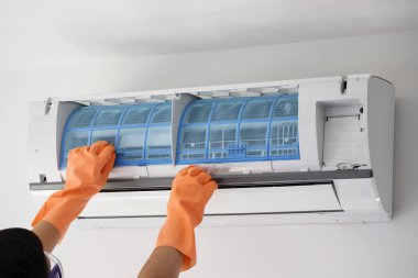 Asyalı adam elinde klima filtre temizleme konsepti