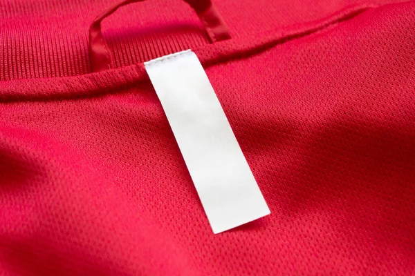 Etiqueta Ropa Blanca Blanco Sobre Fondo Textura Jersey Rojo — Foto de Stock