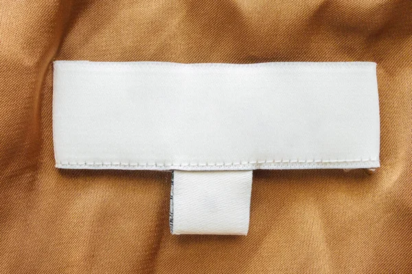 Пустая Белая Этикетка Белья Ухода Одеждой Коричневом Фоне Текстуры Ткани — стоковое фото