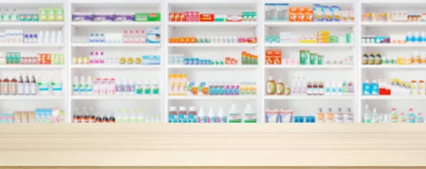 Empty wood counter top with pharmacy drugstore shelves blur pharmaceutical medicine product background