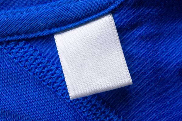Cucian Putih Kosong Label Pakaian Perawatan Pada Latar Belakang Tekstur — Stok Foto