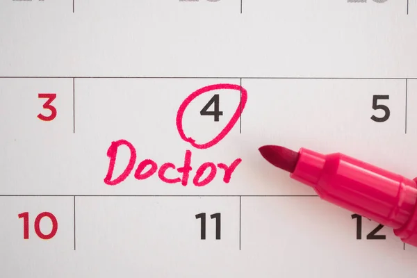 important doctor appointment schedule write on white calendar page date close up