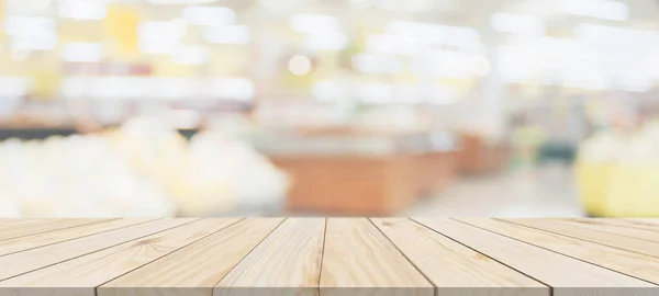 Wood table top with supermarket grocery store blurred background with bokeh light for product display