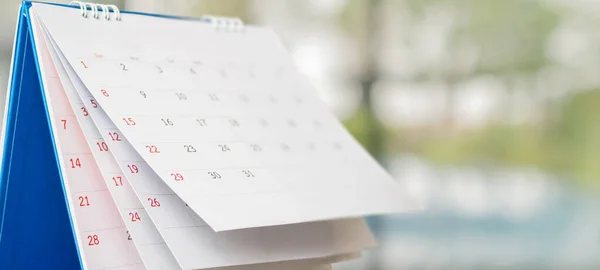 Bulanık bokeh arkaplan randevusu ve iş görüşmesi kavramına sahip beyaz kağıt masa takvimini kapat