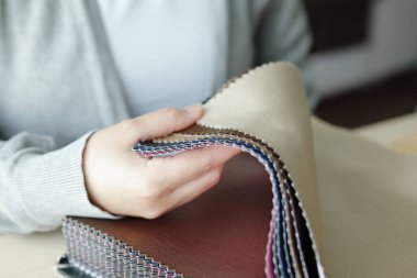 Kumaş rengi örnekleri olan kadın tasarımcı perde için tekstil seçiyor