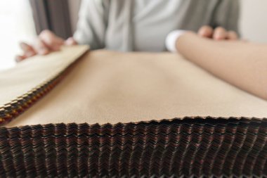 Kumaş rengi örnekleri olan kadın tasarımcı perde için tekstil seçiyor