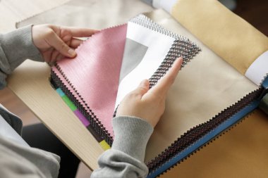 Kumaş rengi örnekleri olan kadın tasarımcı perde için tekstil seçiyor