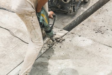 İnşaat işçisi beton sondaj yüzeyi kullanıyor.