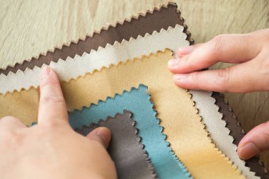 Kumaş rengi örnekleri olan kadın tasarımcı perde için tekstil seçiyor