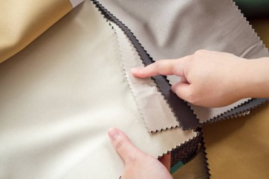 Kumaş rengi örnekleri olan kadın tasarımcı perde için tekstil seçiyor