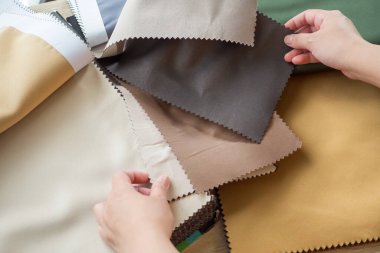 Kumaş rengi örnekleri olan kadın tasarımcı perde için tekstil seçiyor