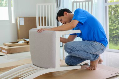 Beyaz koltuk mobilyalarını evde monte eden adam.