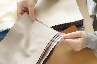 Kumaş rengi örnekleri olan kadın tasarımcı perde için tekstil seçiyor