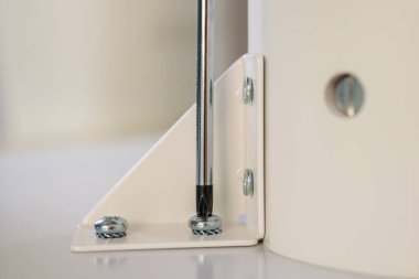 Asyalı adam beyaz masa mobilyalarını evde monte ediyor.