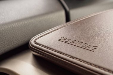 Modern arabanın kahverengi deri dokusunda hava yastığı güvenlik işareti var.