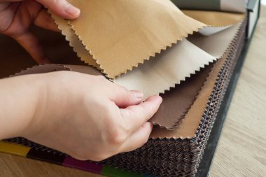 Kumaş rengi örnekleri olan kadın tasarımcı perde için tekstil seçiyor