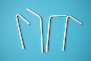 Biyo-çözünebilir çevre dostu beyaz kağıt mavi arka planda saman içiyor