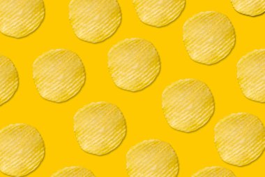 Sarı arka planda patates cipsi deseni düz yerde yatıyordu.