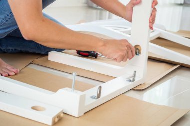 Beyaz koltuk mobilyalarını evde monte eden adam.