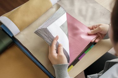 Kumaş rengi örnekleri olan kadın tasarımcı perde için tekstil seçiyor