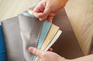 Kumaş rengi örnekleri olan kadın tasarımcı perde için tekstil seçiyor