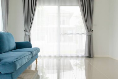 Oturma odasındaki mavi kanepe. Evin arka planı.