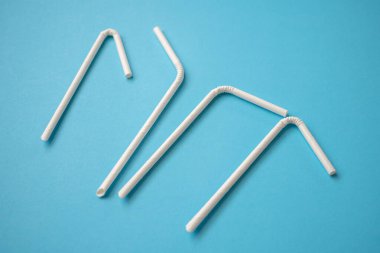 Biyo-çözünebilir çevre dostu beyaz kağıt mavi arka planda saman içiyor