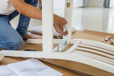 Beyaz koltuk mobilyalarını evde monte eden adam.