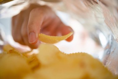 Atıştırmalık çantanın içinde patates cipsi topluyorum.