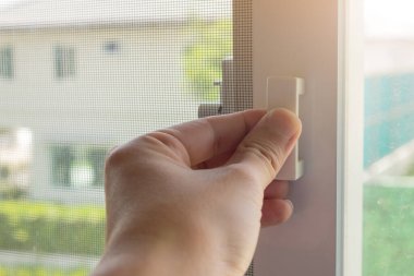 Ev penceresinde el ele tutuşan sivrisinek ağı tel ekran sapı