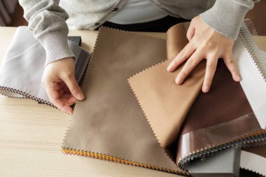 Kumaş rengi örnekleri olan kadın tasarımcı perde için tekstil seçiyor