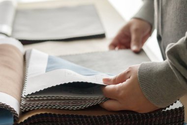 Kumaş rengi örnekleri olan kadın tasarımcı perde için tekstil seçiyor