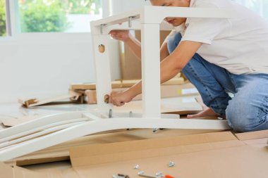 Beyaz koltuk mobilyalarını evde monte eden adam.