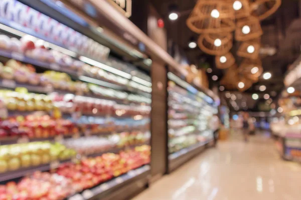 Fresh fruits and vegetables shelves in grocery store blurred background