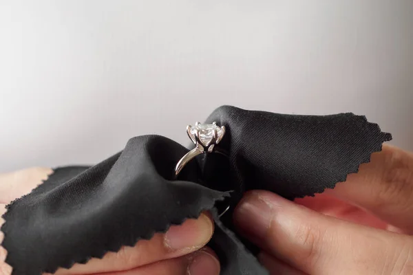 Jeweller cleaning jewelry diamond ring with fabric cloth