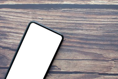 Ahşap masa arkasında akıllı telefon rengi siyah beyaz ekran. Kapanış fotoğrafçılığı, tasarım ve metin için boş telif alanı beyaz ekran, kırpma yolu var