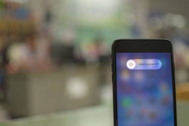 Songkhla, Hatyai, Tayland 5 Kasım 2020: Elle tutulan Apple iPhone 7 artı ekranda güç kapama seçeneği olan bir ofiste siyah renk, yakın çekim fotoğrafçılık, bulanık arkaplan çok güzel