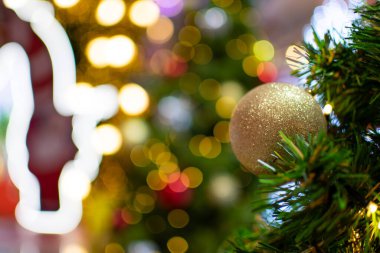 2020 'de süslenmiş küçük ampullerle süslenmiş bir Noel ağacındaki büyük altın toplar çok güzeldir. Tasarım veya metin için boşluk ve güzel bokeh 'i sol tarafa kopyala, bulanık arkaplan.