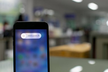 Songkhla, Hatyai, Tayland 5 Kasım 2020: Elle tutulan Apple iPhone 7 artı ekranda güç kapama seçeneği olan bir ofiste siyah renk, yakın çekim fotoğrafçılık, bulanık arkaplan çok güzel