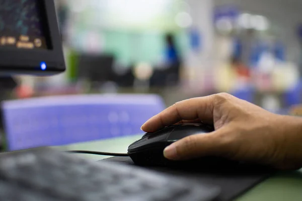 Ofisteki cam masanın üzerinde bilgisayarla çalışan bir adamı kapatmak için, adamın elindeki fareye tıklayarak, internetteki mali bilgileri görebilirsiniz. Ofiste çalışan erkek personel. Bulanık arkaplan