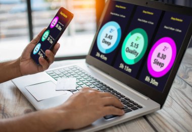 Adam akıllı telefonu uyku fonksiyonu monitörünü izlemek için tutuyor. Mobil cihaz ekranı sağlığı izler. Teknolojiyi dijital cihazlar ve internet kullanarak insan sağlığını korumak için kullanma kavramı. Seçici odak