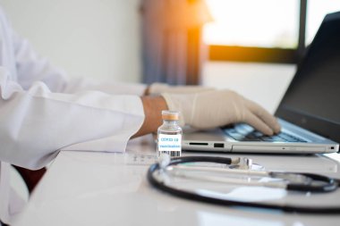 Coronavirus aşısı şişeleri laboratuvardaki masanın üzerine konur. Bir doktorun laboratuvar konsepti koronavirüs hastalığına (COVID-19) bir çare bulmuştur. - Yakın çekim. Seçici odaklanma. Bulanık arkaplan.