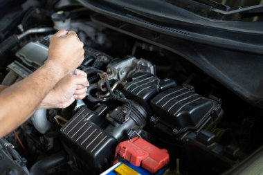 Motor bakımı kavramı. Motor tamirinde vidaları sıkmak için ingiliz anahtarı tamircilerde tutuluyor. Araba motoru kapandı. Mühendisler silindirlerin yanma sistemini kontrol ediyorlar. Seçici odaklanma. Bulanık arkaplan